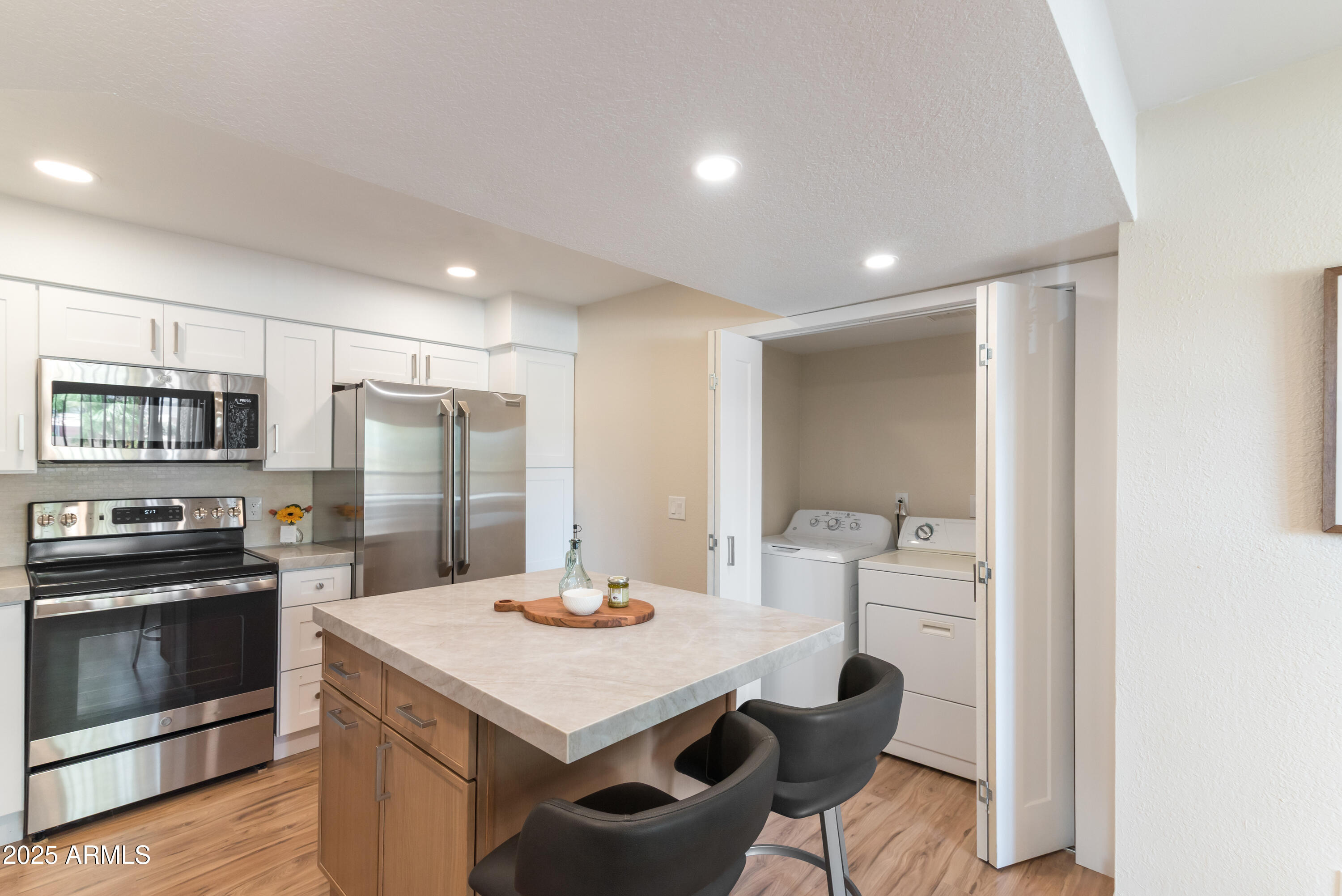 8787 East Mountain View Road, Unit 2101 Scottsdale, AZ 85258 - Photo 7 of 39 a kitchen with stainless steel appliances kitchen island granite countertop a kitchen island hardwood floor and a sink