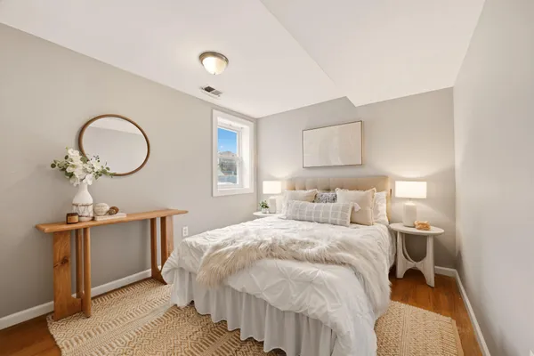 a view of a bedroom with wooden floor and stairs
