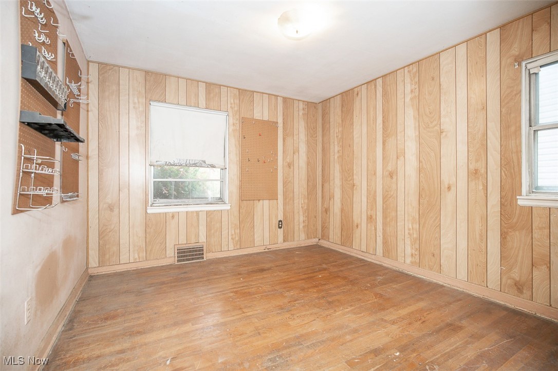 23901 Colbourne Road Euclid, OH 44123 - Photo 11 of 18 Spare room with wood finished floors and wooden walls