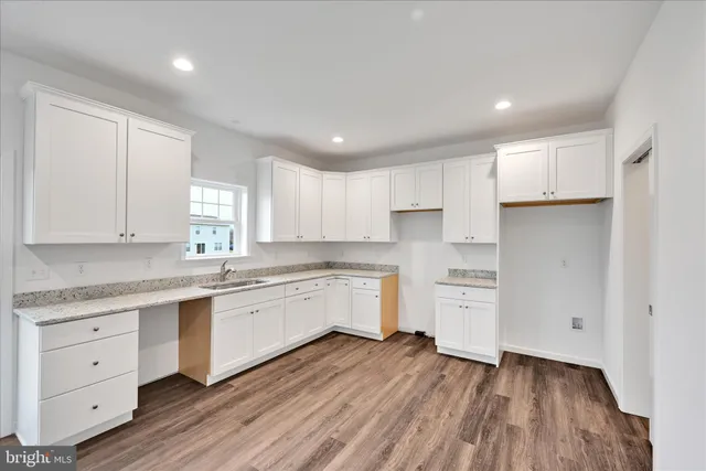a kitchen with cabinets oven a sink and dishwasher with wooden floor