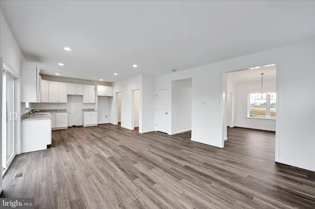 a view of kitchen and front door with wooden floor