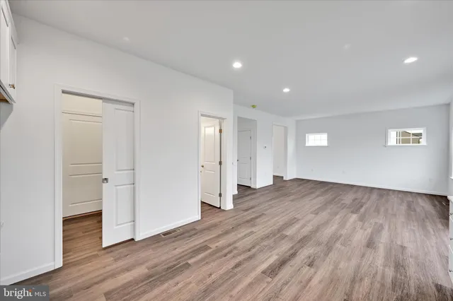 a view of empty room with wooden floor