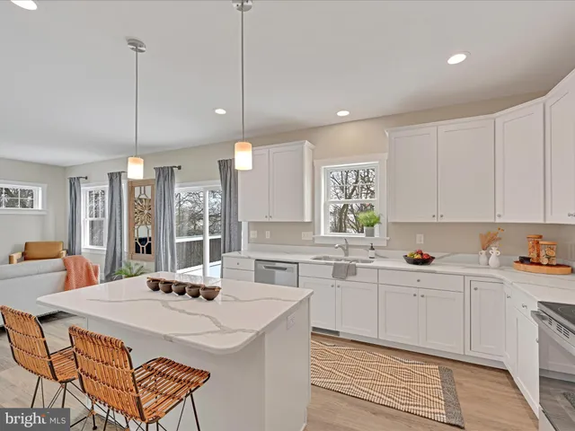 a kitchen with stainless steel appliances kitchen island a sink a stove a refrigerator and cabinets