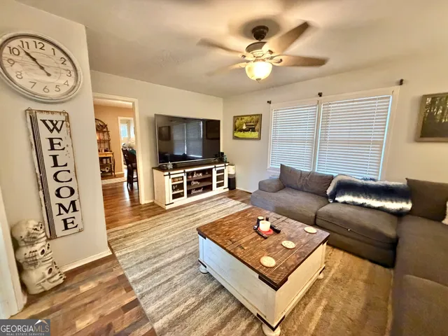a living room with furniture a flat screen tv and a wall clock