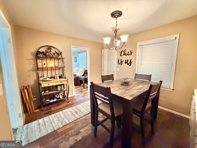 a view of a dining room with furniture a chandelier and wooden floor