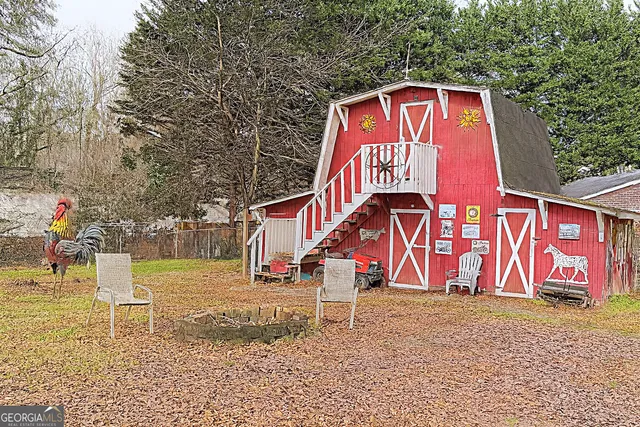 a front view of house with yard outdoor seating and covered with trees