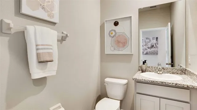 a bathroom with a granite countertop toilet sink and mirror