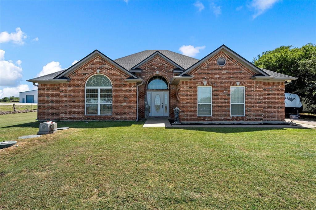 Brick facade residence with a dark shingled roof