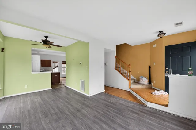 a view of a livingroom with wooden floor and stairs