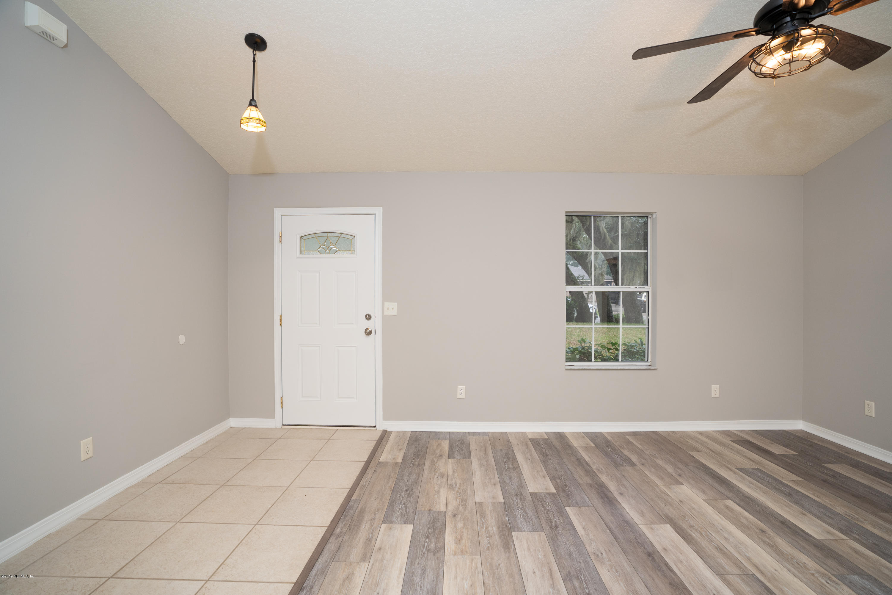 159 Hawthorne Road St. Augustine, FL 32086 - Photo 4 of 33 a view of an empty room with a window and wooden floor
