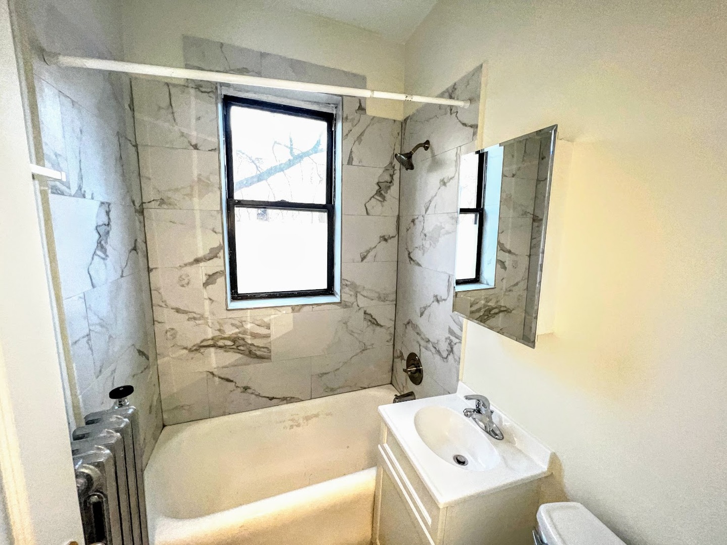 839 West Sheridan Road, Unit 422 Chicago, IL 60613 - Photo 7 of 10 a bathroom with a white bath tub sitting next to a white sink and a shower