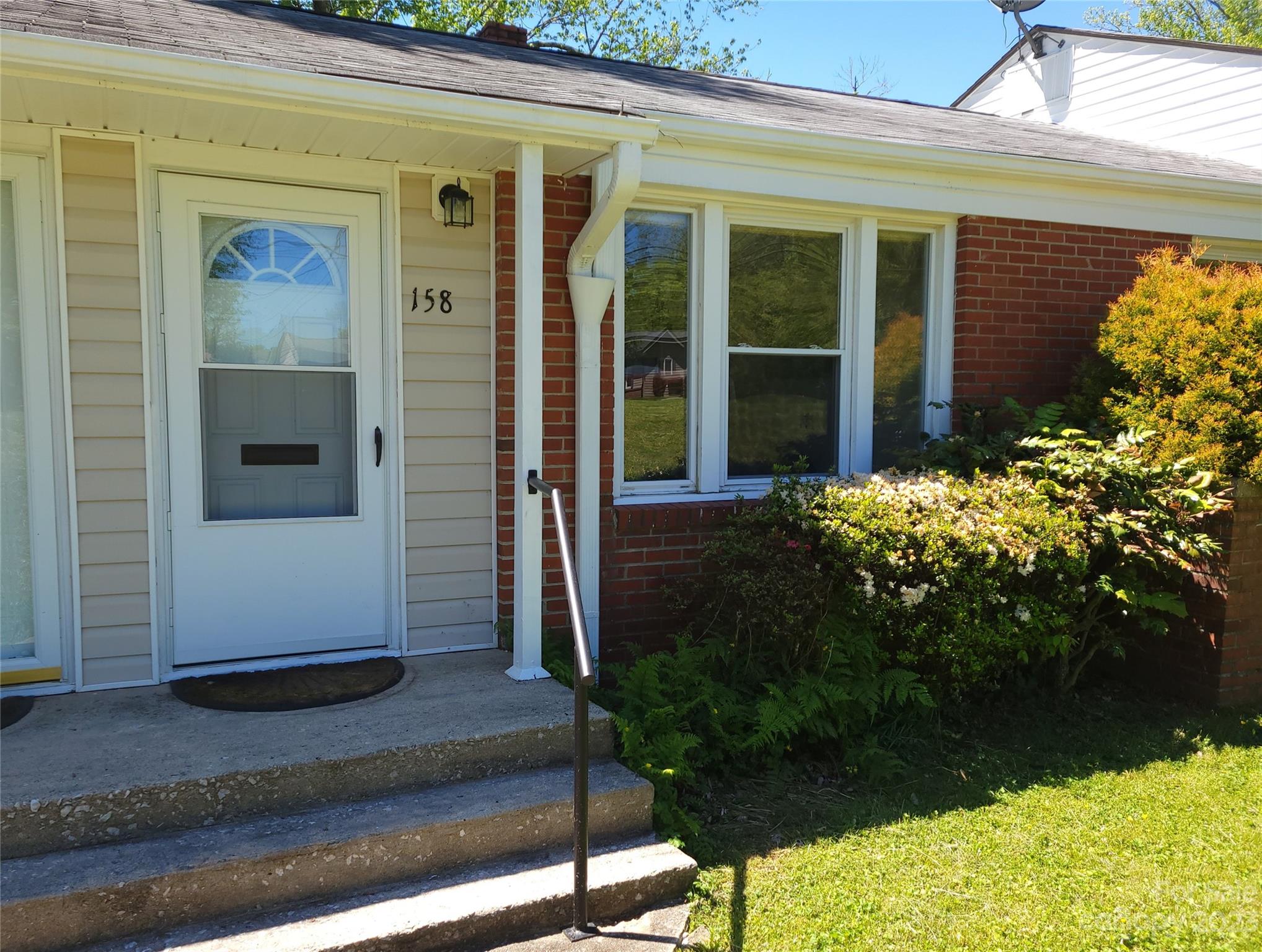 158 Elm Bend Road Brevard, NC 28712 - Photo 1 of 15 a front view of a house with garden