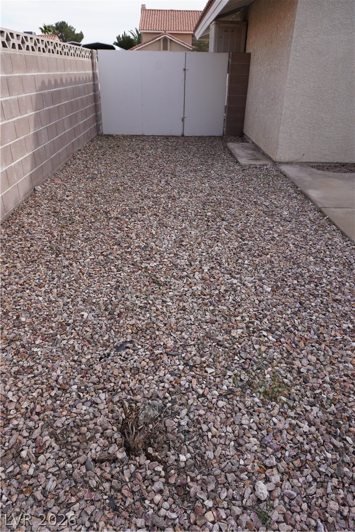8328 Del Rey Avenue Las Vegas, NV 89117 - Photo 36 of 38 Secure yard access with a sturdy gate and durable rock landscaping.