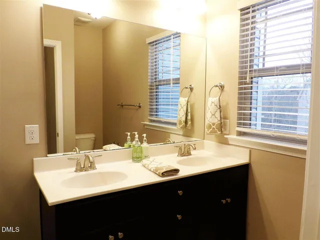 a bathroom with a double vanity sink and a mirror