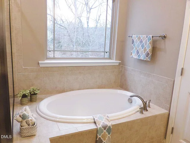 a white bath tub sitting in a bathroom next to a window