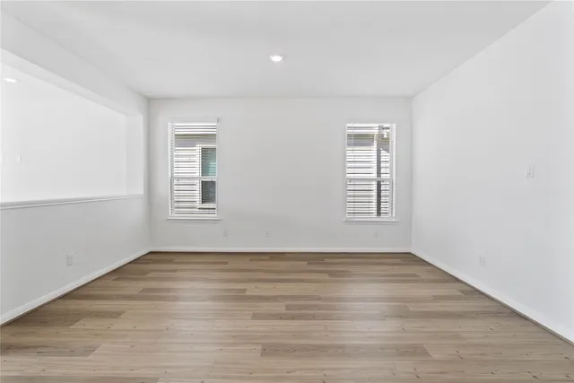 an empty room with fan and windows