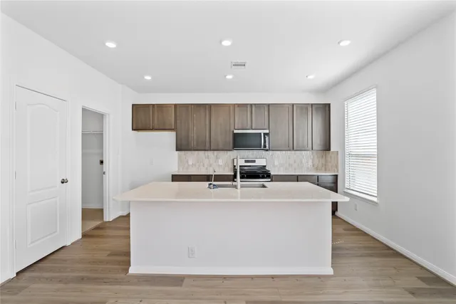 a kitchen with stainless steel appliances granite countertop a sink stove and refrigerator