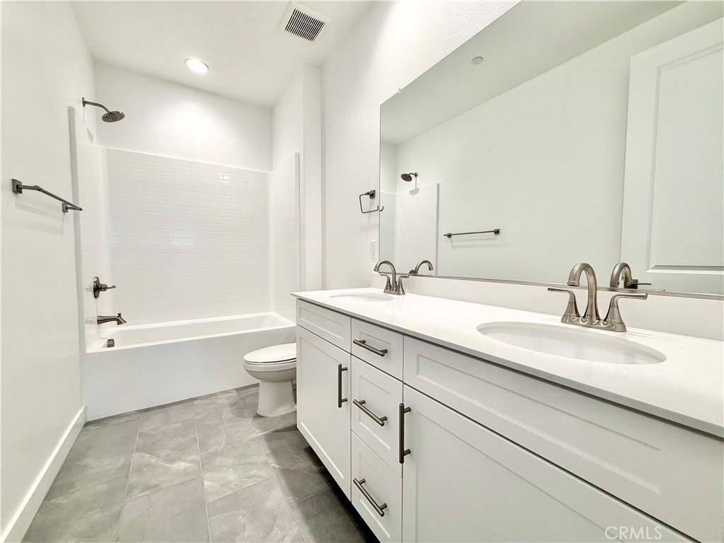 26893 Rubicon Road Menifee, CA 92586 - Photo 19 of 32 a bathroom with a double vanity sink toilet mirror and bathtub