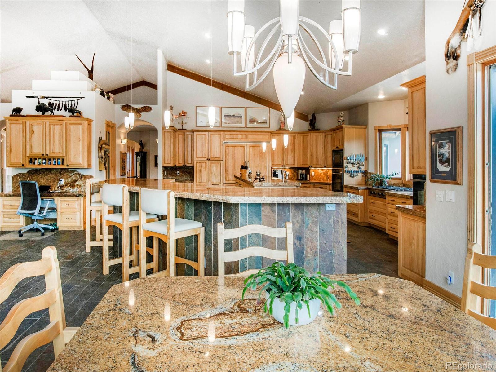 577 Bear Meadow Trail Evergreen, CO 80439 - Photo 11 of 40 a kitchen with stainless steel appliances kitchen island granite countertop a stove and cabinets