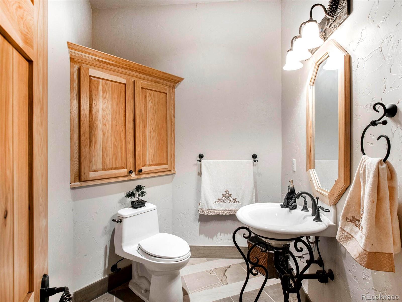 577 Bear Meadow Trail Evergreen, CO 80439 - Photo 15 of 40 a bathroom with a sink a toilet and mirror
