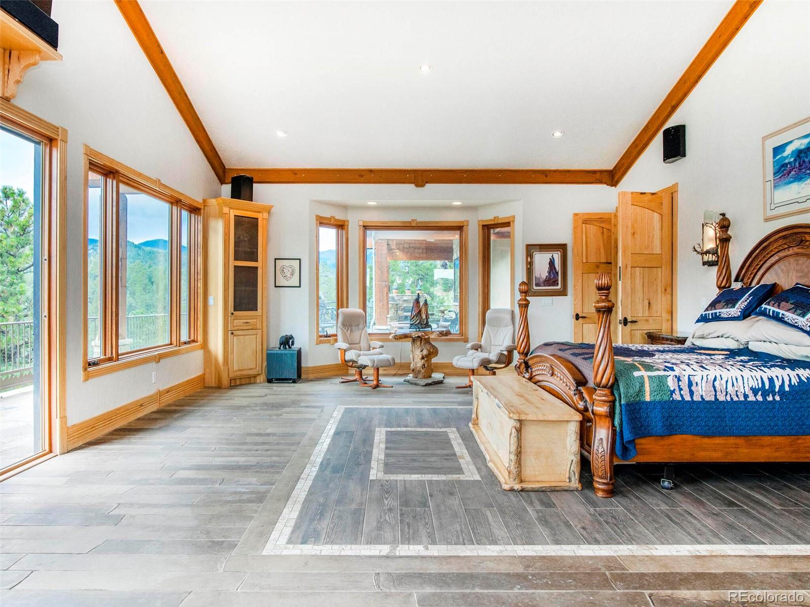 577 Bear Meadow Trail Evergreen, CO 80439 - Photo 19 of 40 a living room with furniture a rug and a large window