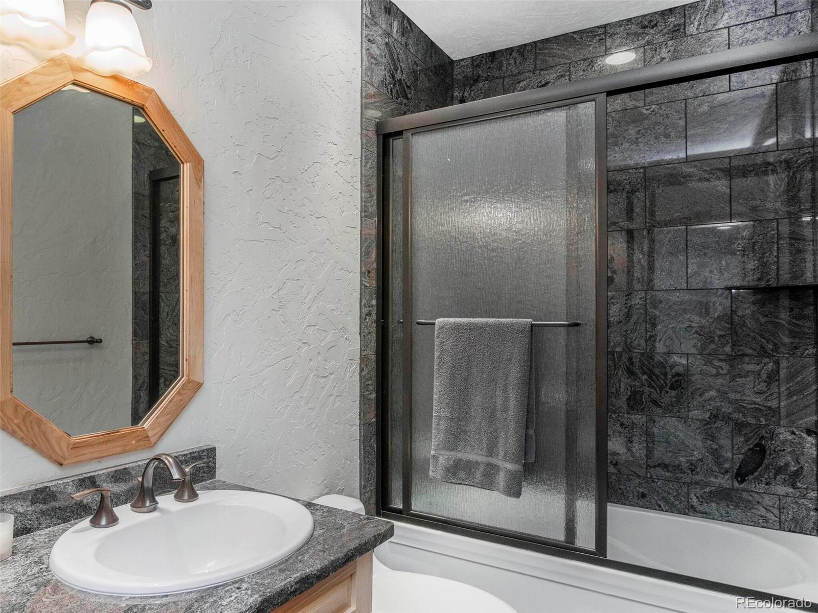 577 Bear Meadow Trail Evergreen, CO 80439 - Photo 33 of 40 a bathroom with a sink mirror and shower