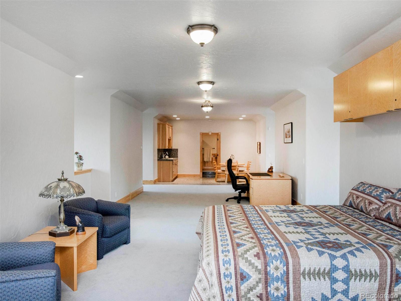 577 Bear Meadow Trail Evergreen, CO 80439 - Photo 36 of 40 a bedroom with furniture and a chandelier