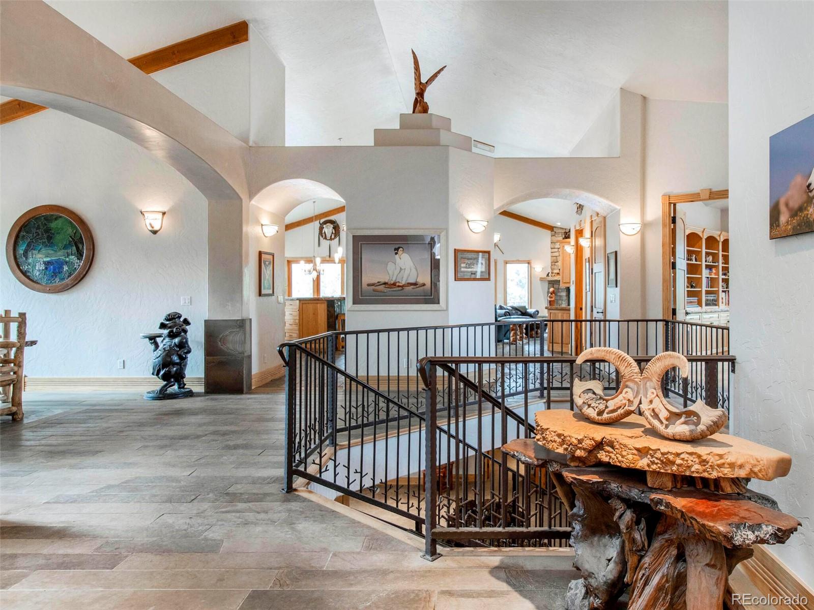 577 Bear Meadow Trail Evergreen, CO 80439 - Photo 6 of 40 a view of a hallway with a dining table and chairs