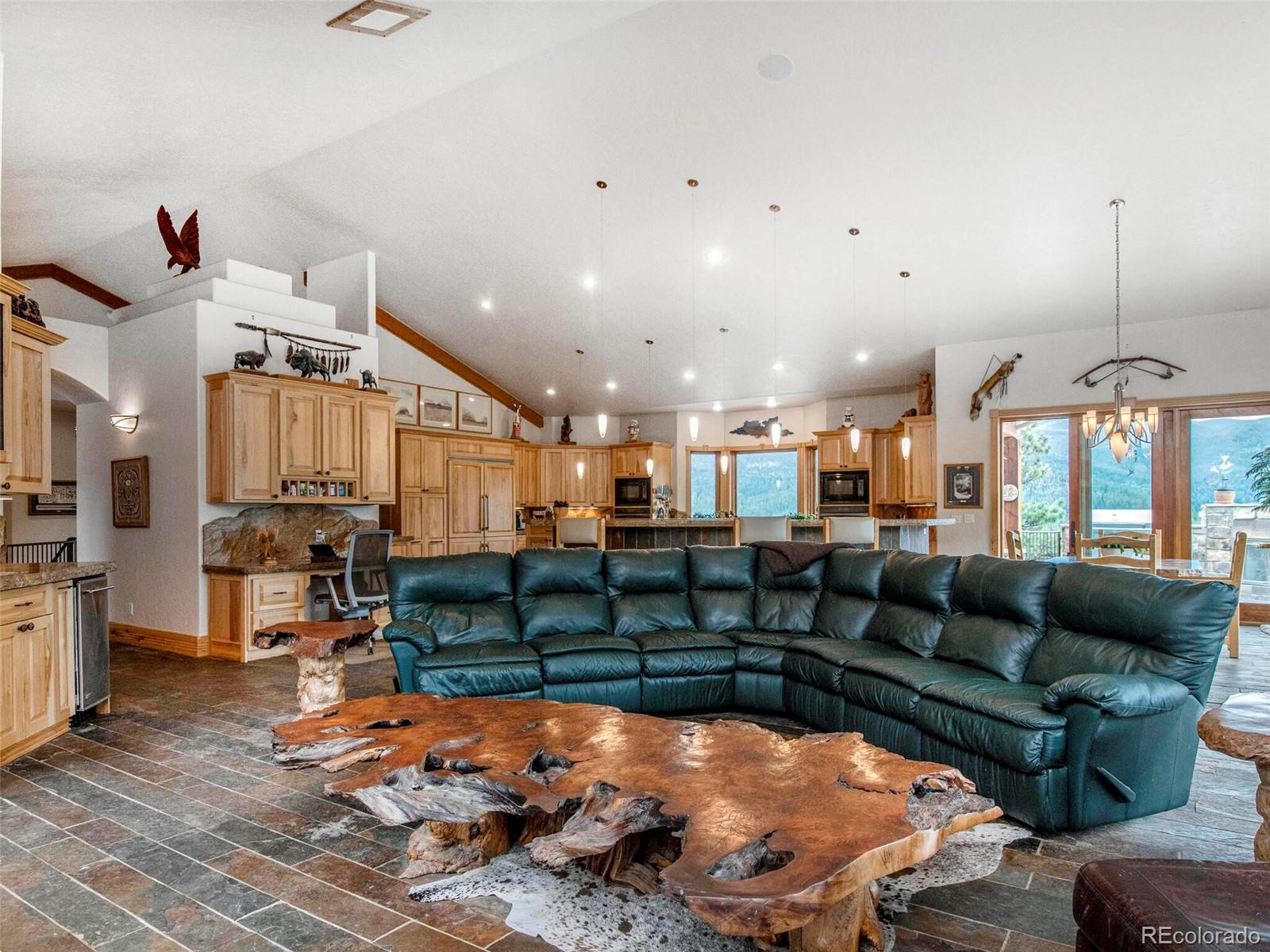 577 Bear Meadow Trail Evergreen, CO 80439 - Photo 9 of 40 a living room with lots of furniture and a chandelier