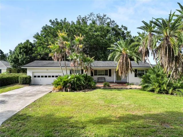a front view of a house with yard and tree