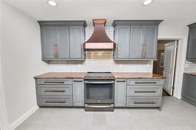 a kitchen with granite countertop white cabinets and stainless steel appliances