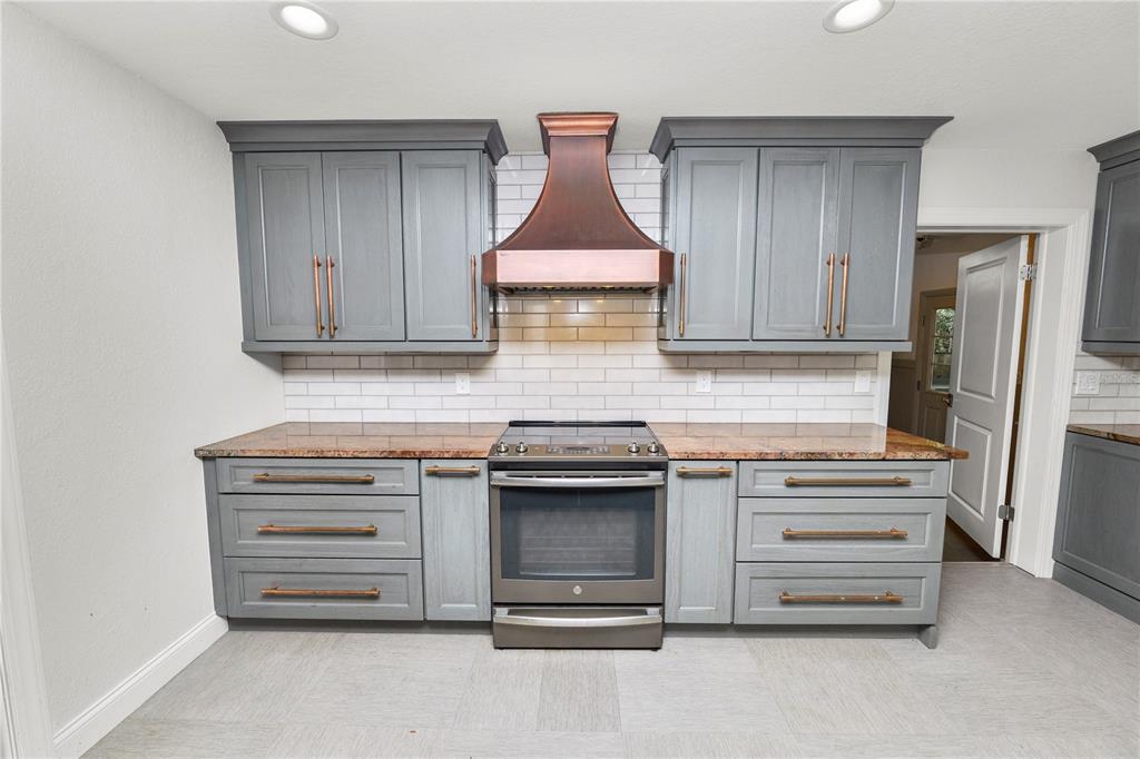 509 Robroy Street Lakeland, FL 33813 - Photo 12 of 51 a kitchen with granite countertop white cabinets and stainless steel appliances