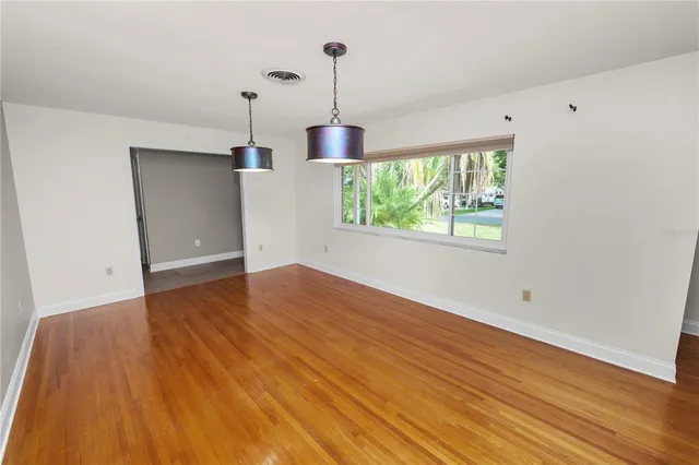 a view of empty room with wooden floor and fireplace