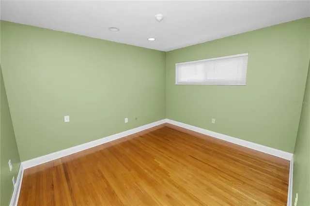 a view of a big room with wooden floor and windows