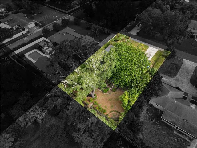 an aerial view of residential houses with outdoor space and trees