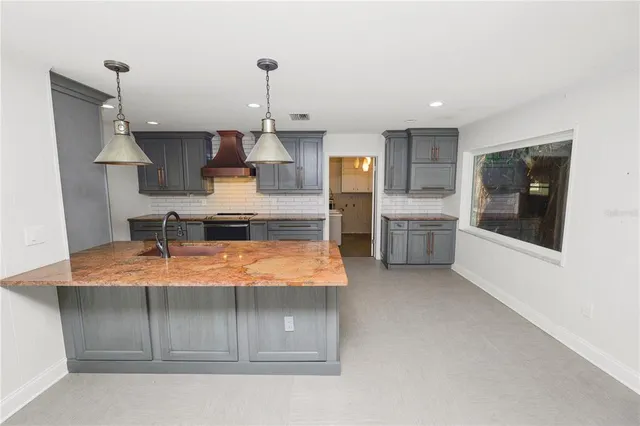 a kitchen with stainless steel appliances granite countertop a sink a stove and a refrigerator