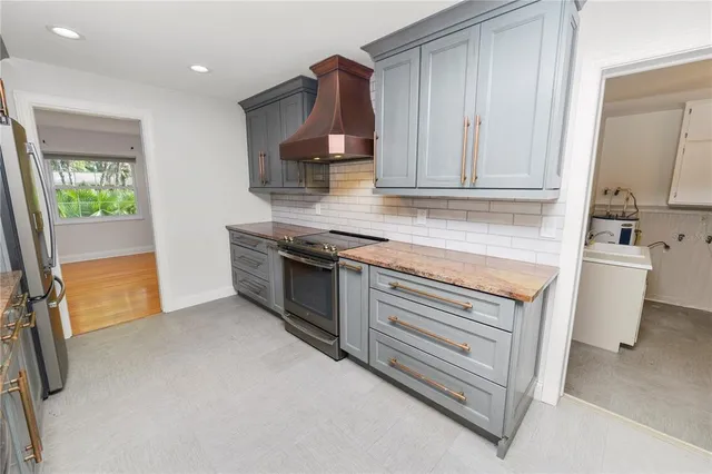 a kitchen with stainless steel appliances granite countertop a sink and a stove top oven