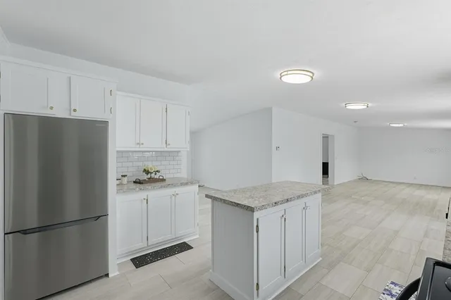 a kitchen with a refrigerator a stove and white cabinets