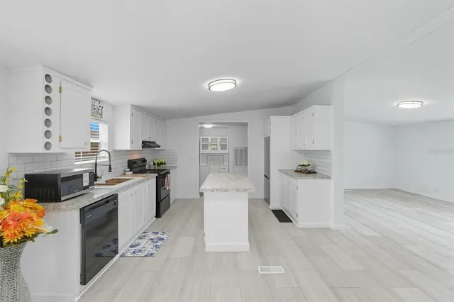a kitchen with granite countertop a sink cabinets and stainless steel appliances
