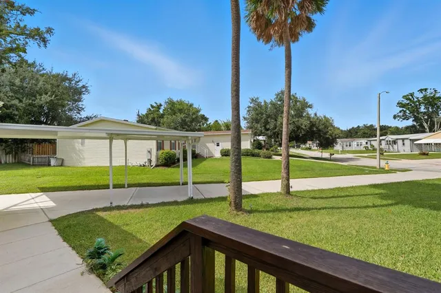 a view of a house with a yard and palm tree