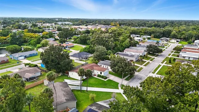 an aerial view of residential houses with outdoor space and trees