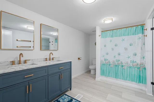 a bathroom with a double vanity sink mirror and shower