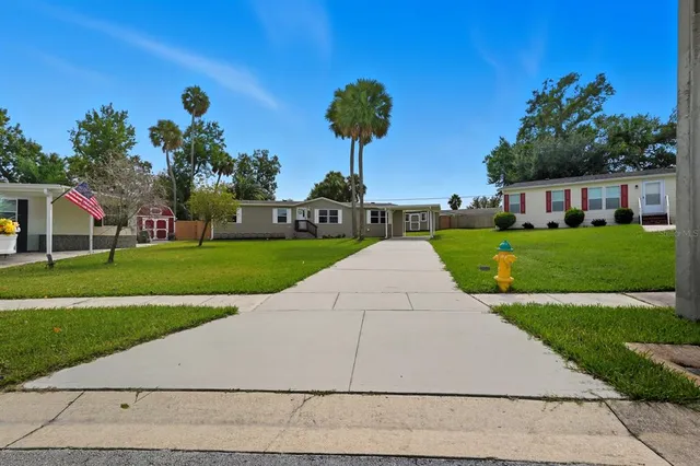 a white house with a yard and potted plants