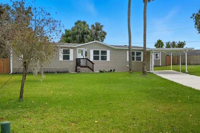 a view of a house with a yard and sitting area