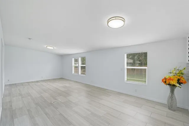 an empty room with wooden floor and a window