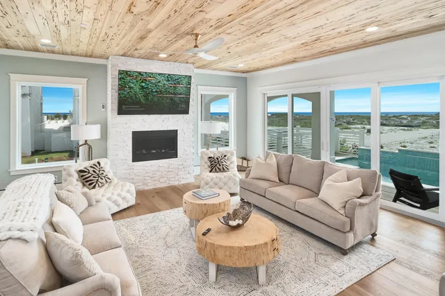 a living room with furniture a fireplace and a large window