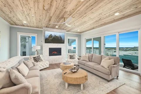 a living room with furniture a fireplace and a large window