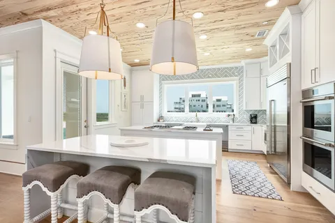 a kitchen with granite countertop a stove a sink and a refrigerator