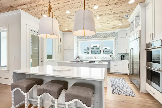 a kitchen with granite countertop a stove a sink and a refrigerator