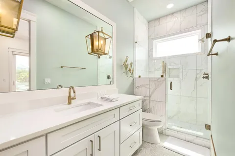 a bathroom with a sink a toilet and shower